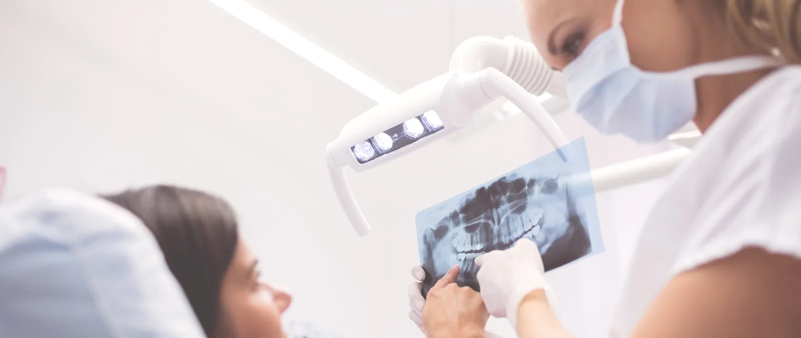 Especialista mostrando una radiografía panorámica a una paciente